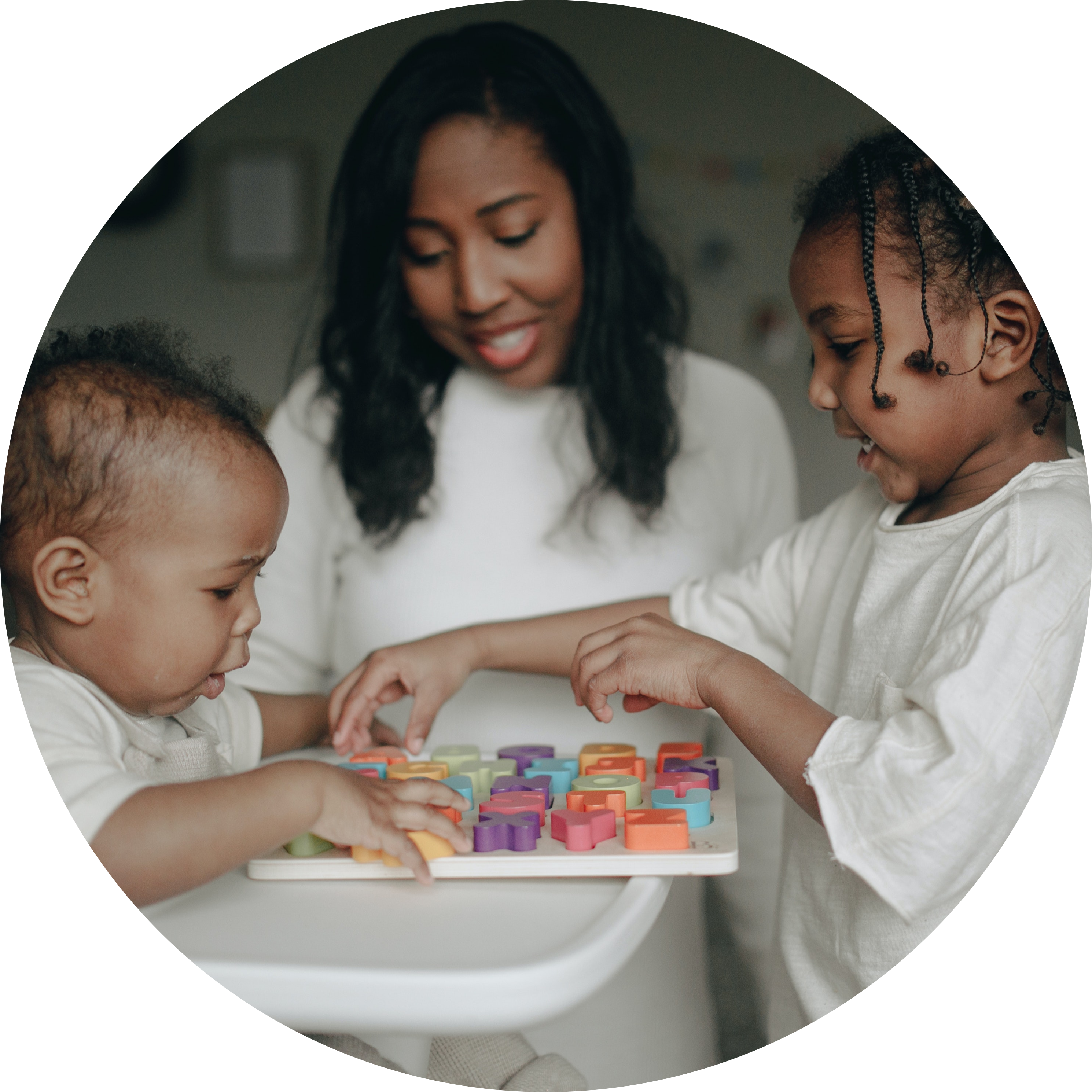 A woman and two children n their home playing with a toy